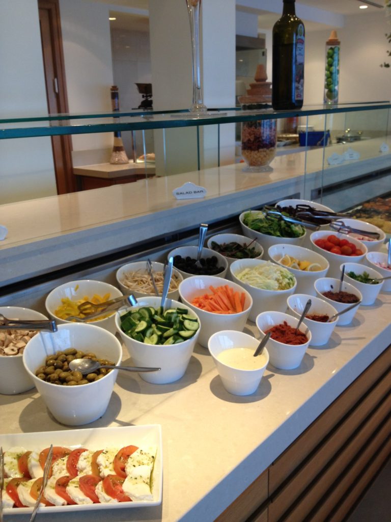 a buffet line of bowls of food