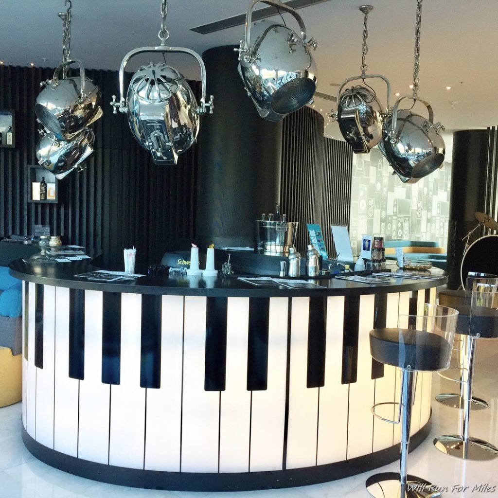 a bar with piano keys and silver pots from ceiling
