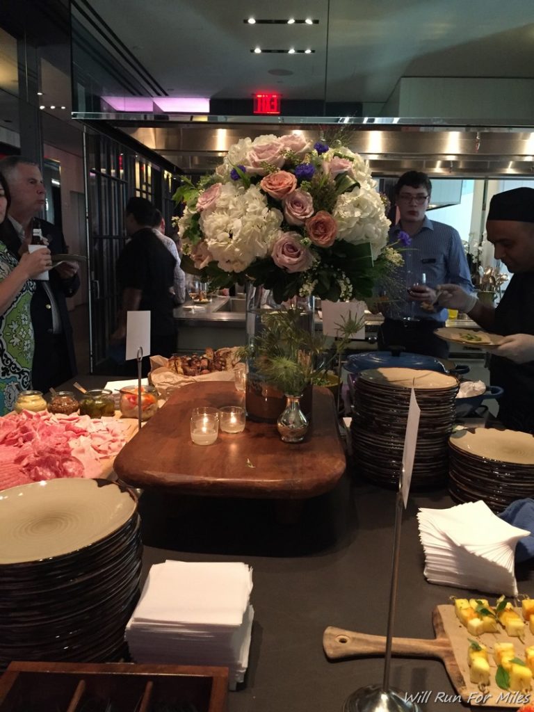 a group of people standing around a table with plates and flowers