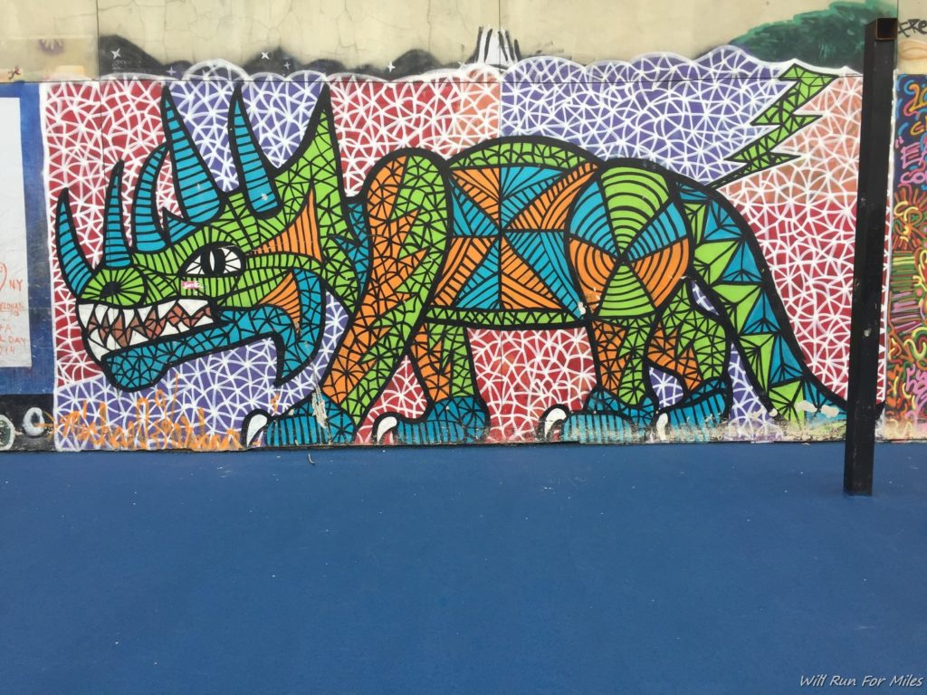 a colorful dinosaur painted on a wall