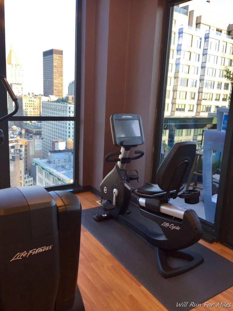 a exercise bike in a room with windows and a city view