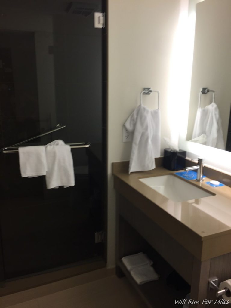 a bathroom with a black door and white towels