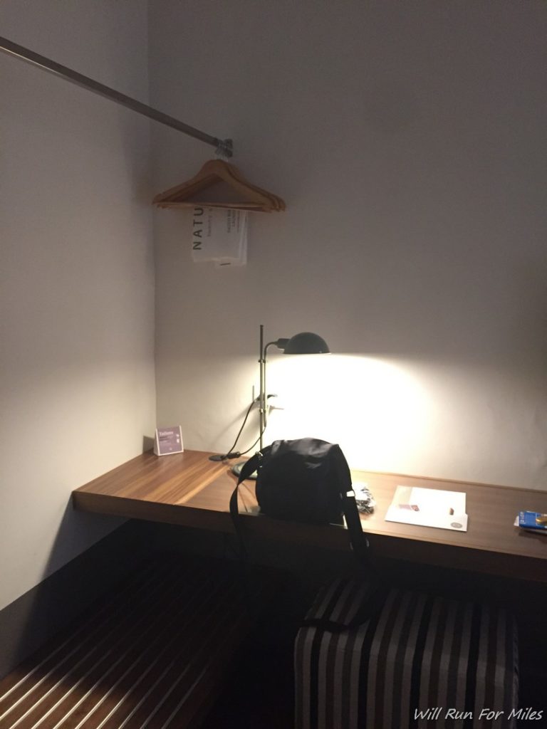 a desk with a lamp and a bag on it