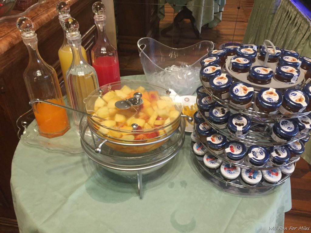 a table with a bowl of fruit and a stack of bottles