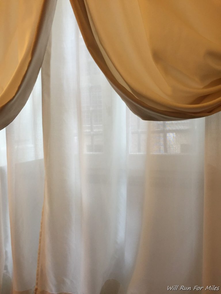 a white curtain with a gold drapes