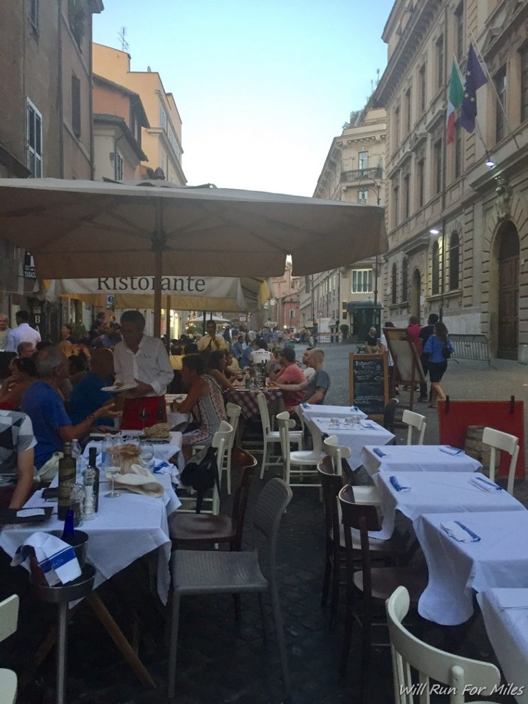 a group of people sitting at tables outside a restaurant
