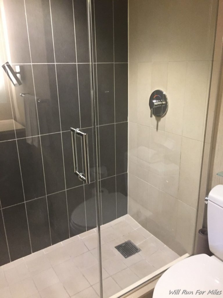a glass shower with a toilet