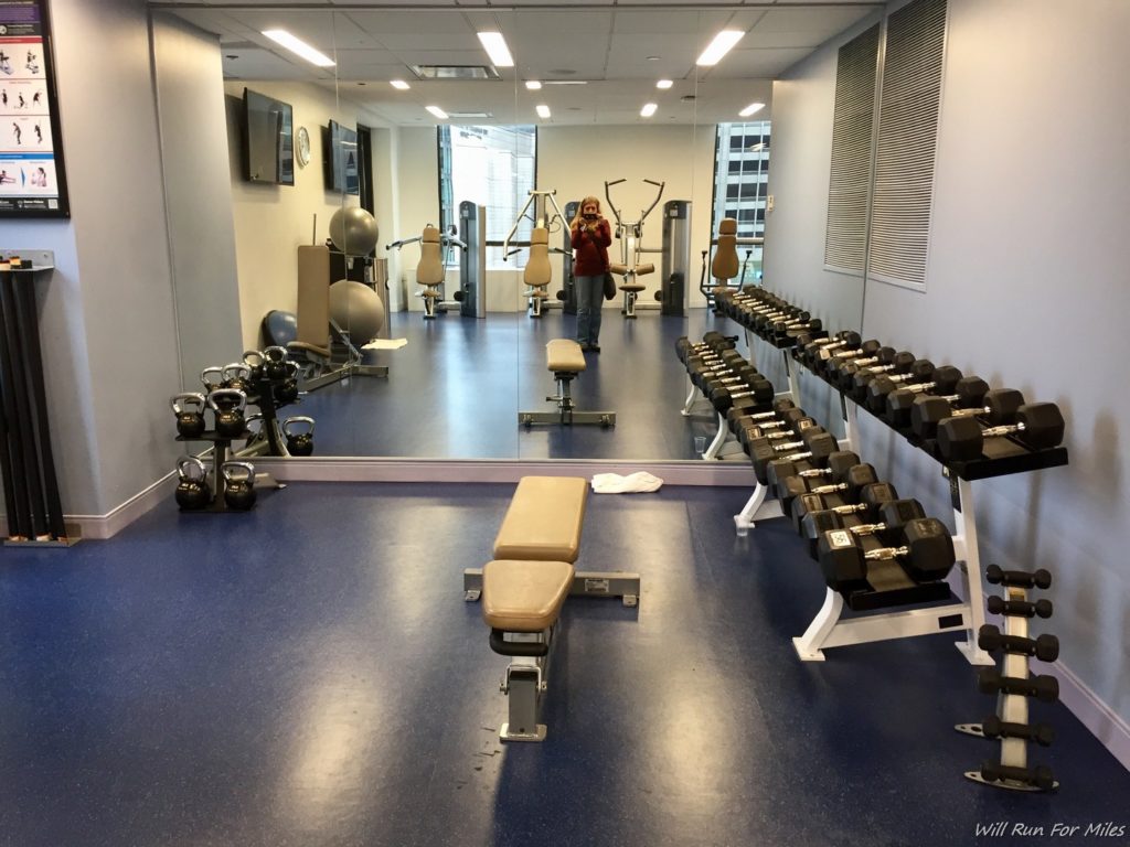 a woman taking a picture of a room with weights
