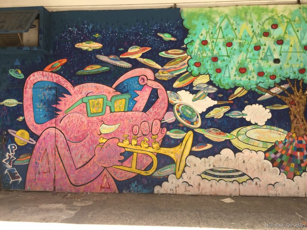 a mural of a pink animal playing a trumpet