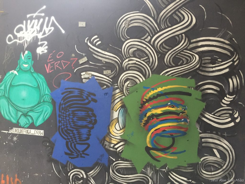 a wall with graffiti and a few pieces of art