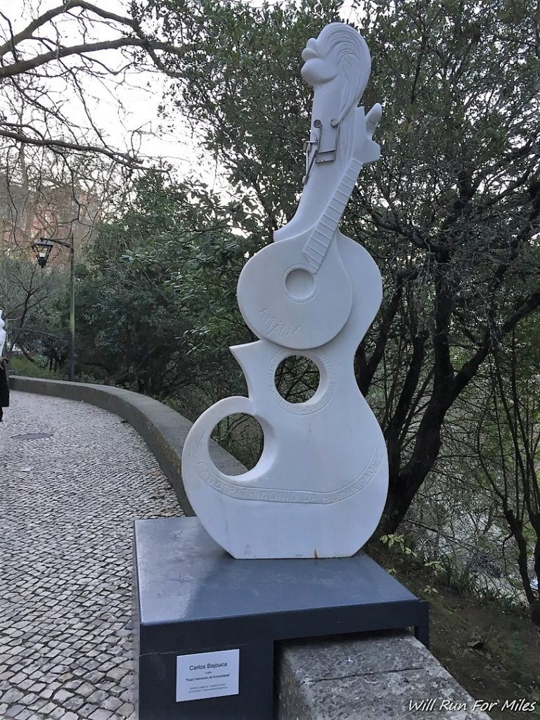 a sculpture of a guitar and a guitar on a stone path