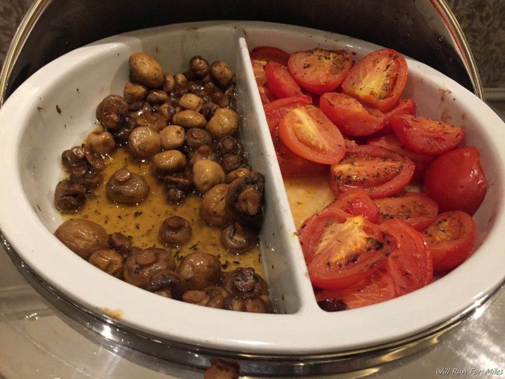 a plate of food with tomatoes and mushrooms