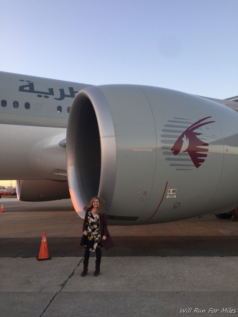 a woman standing in front of a large airplane