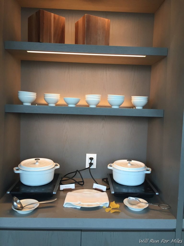 a shelf with white pots and spoons
