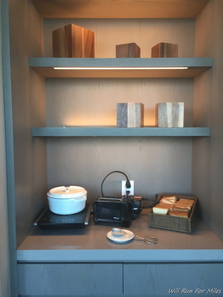 a shelf with a microwave and bread on it