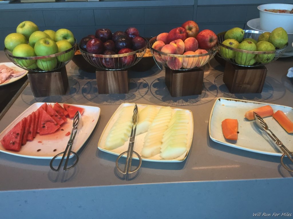 a table with plates of fruit and utensils