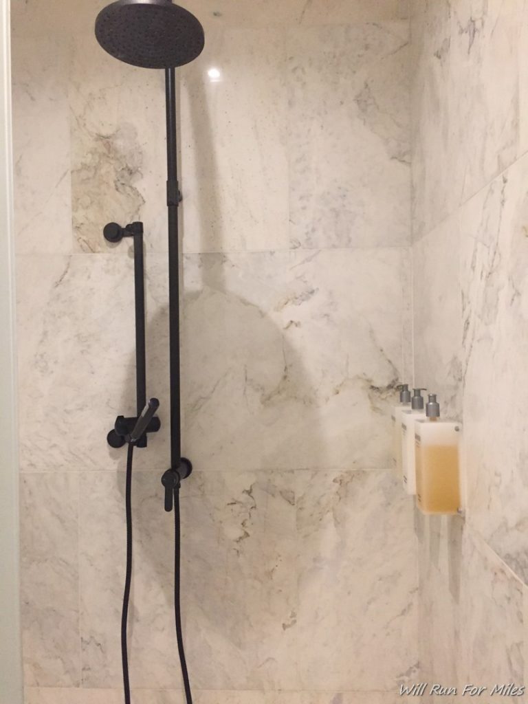 a shower with black pipes and a black shower head