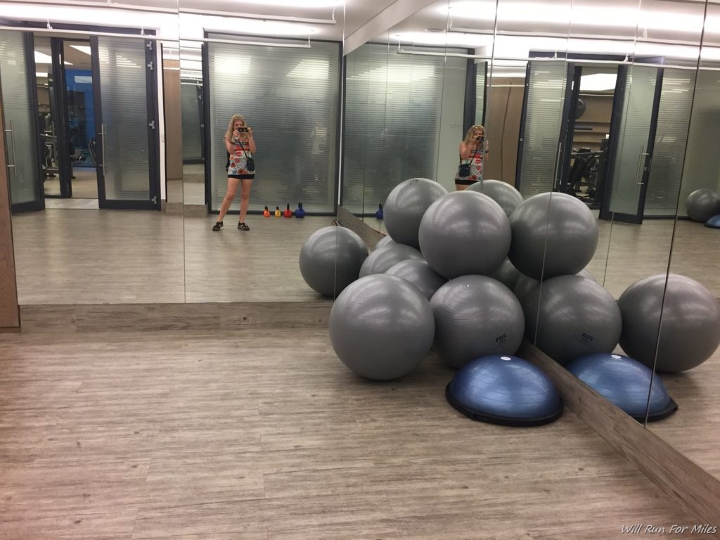 a woman taking a selfie in a gym with large balls