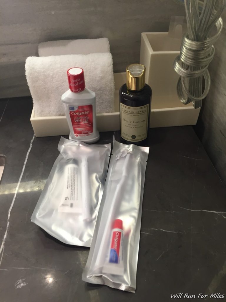 a bathroom sink with toothbrushes and toothpaste