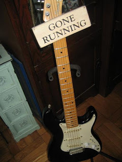 a black and white electric guitar with a sign