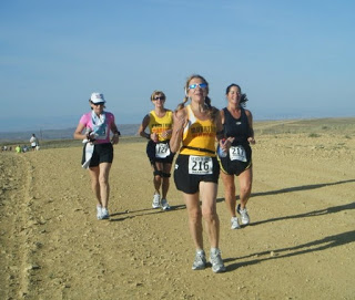 a group of women running on a dirt road
