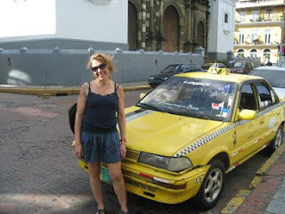 a woman standing next to a yellow taxi