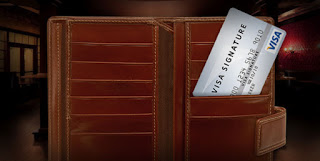 a brown wallet with a visa card in it