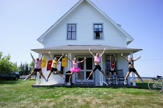 a group of people jumping in front of a house