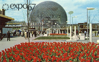 a large circular building with red flowers