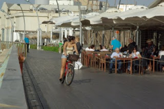 a woman riding a bicycle on a sidewalk