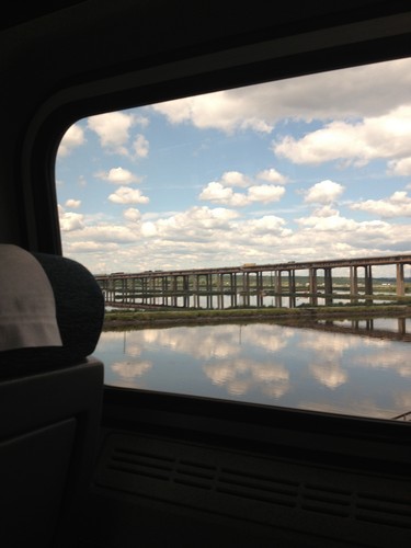 a bridge over water with clouds in the sky