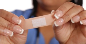 a close-up of a person's hands holding a band aid