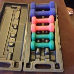 a set of colorful dumbbells in a plastic case