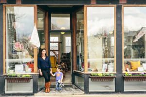 a woman and child standing in front of a store
