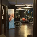 a room with exercise equipment and a poster