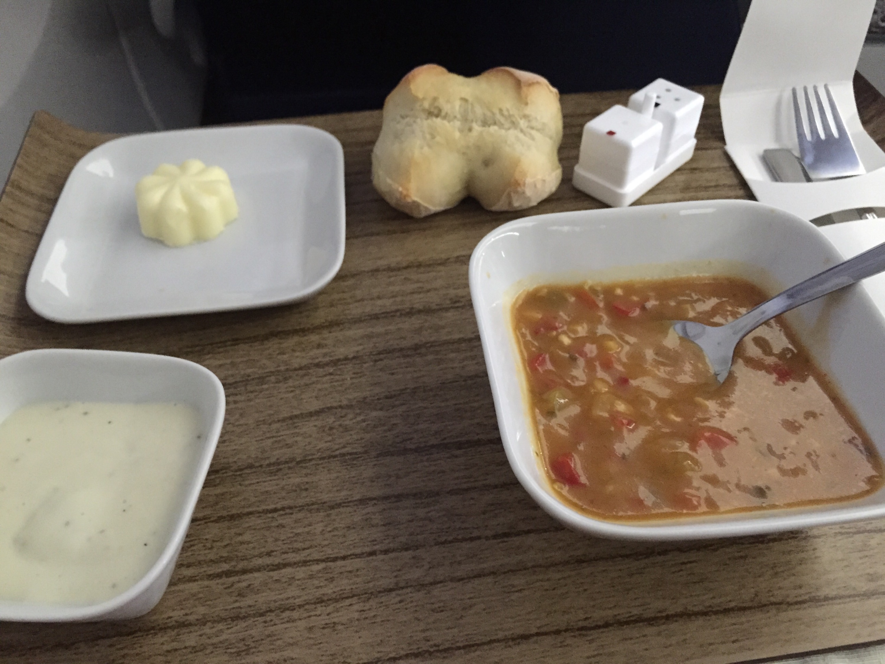 a bowl of soup and a piece of bread on a table