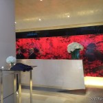 a reception desk with flowers in front of a red wall
