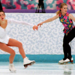 a couple of women skating on ice