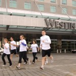 a group of people running in front of a hotel