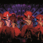 a group of women in red clothing on a stage