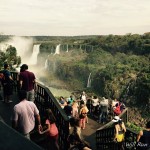 a group of people standing on a deck overlooking a waterfall