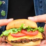 a person holding a hamburger