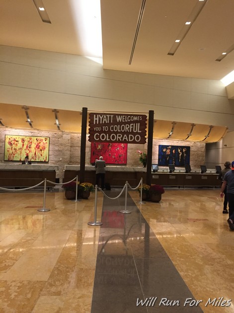 a large lobby with a sign and a couple people standing in front of it