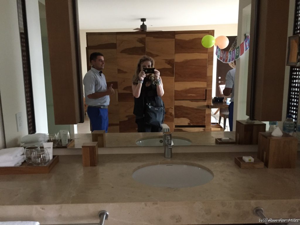 a woman taking a picture of a man in a bathroom