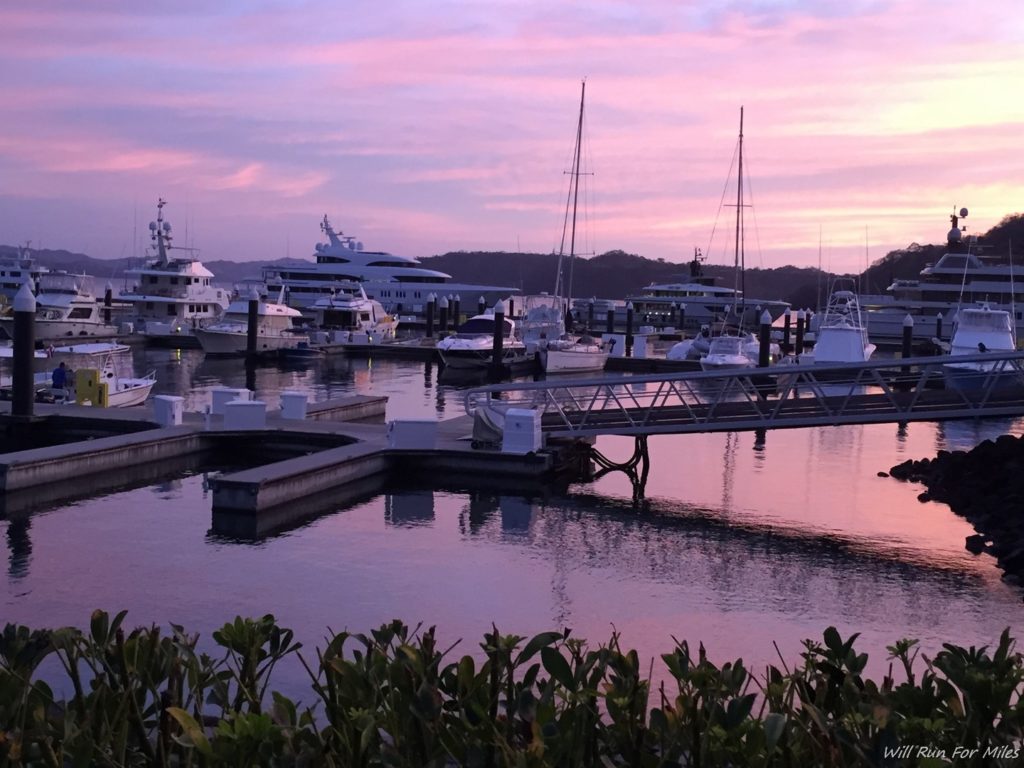 a dock with boats and a dock with a pink sky