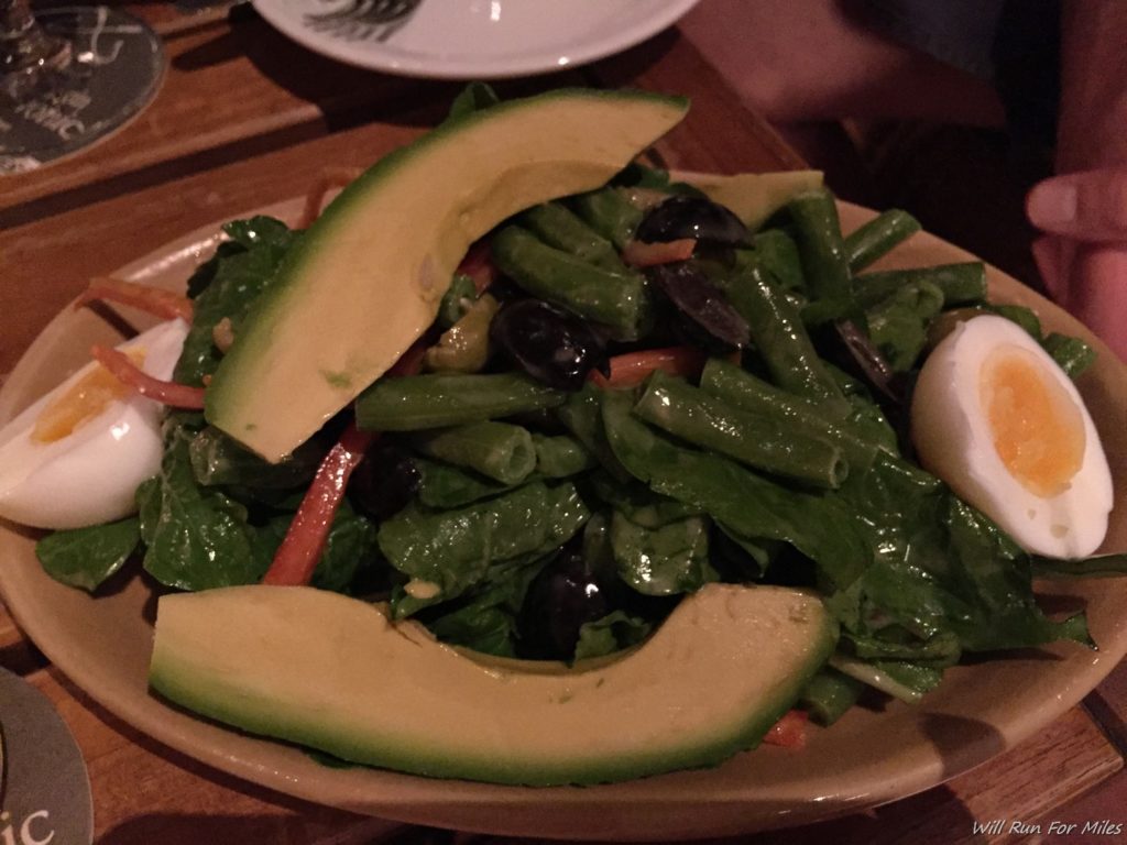 a plate of salad with avocado and eggs