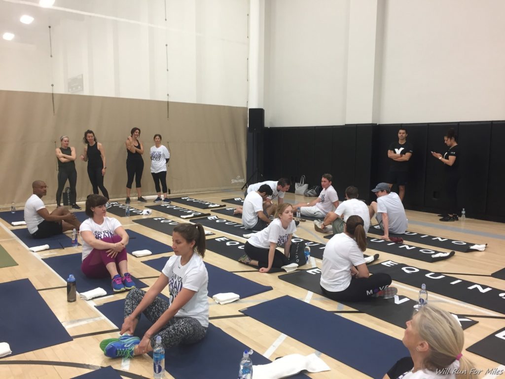 a group of people sitting on mats in a gym