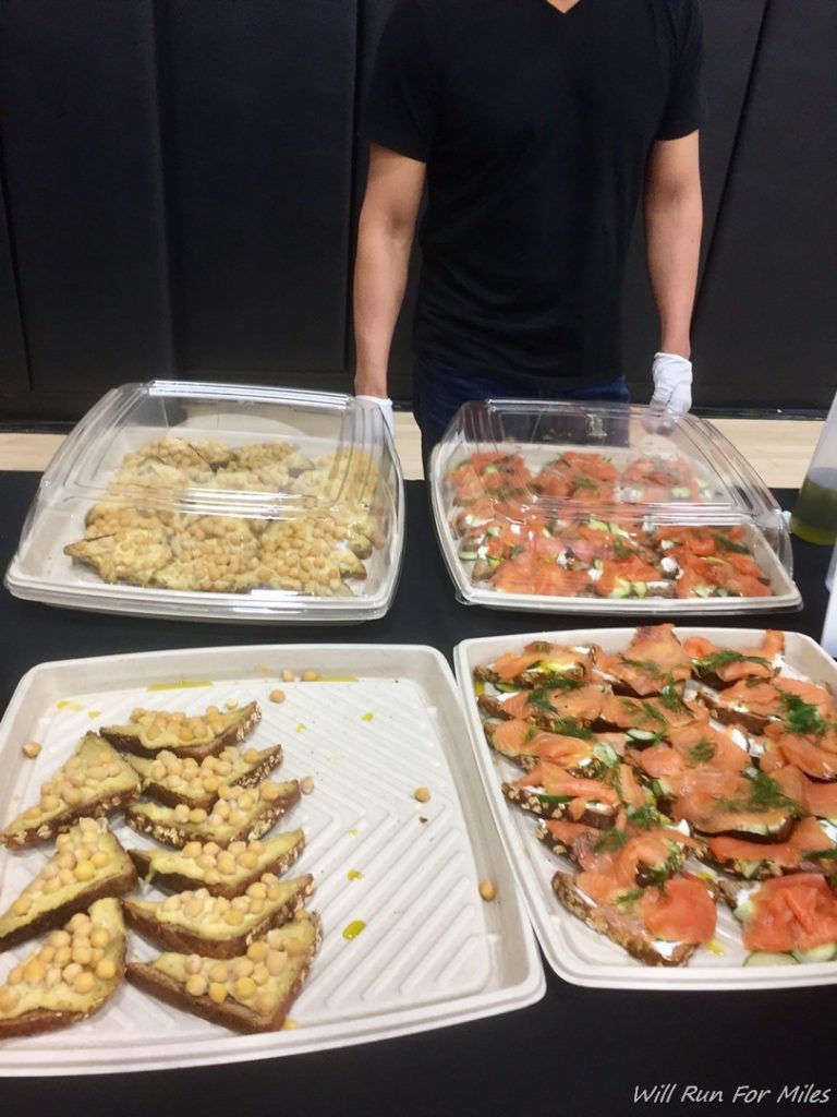 a man standing in front of several trays of food