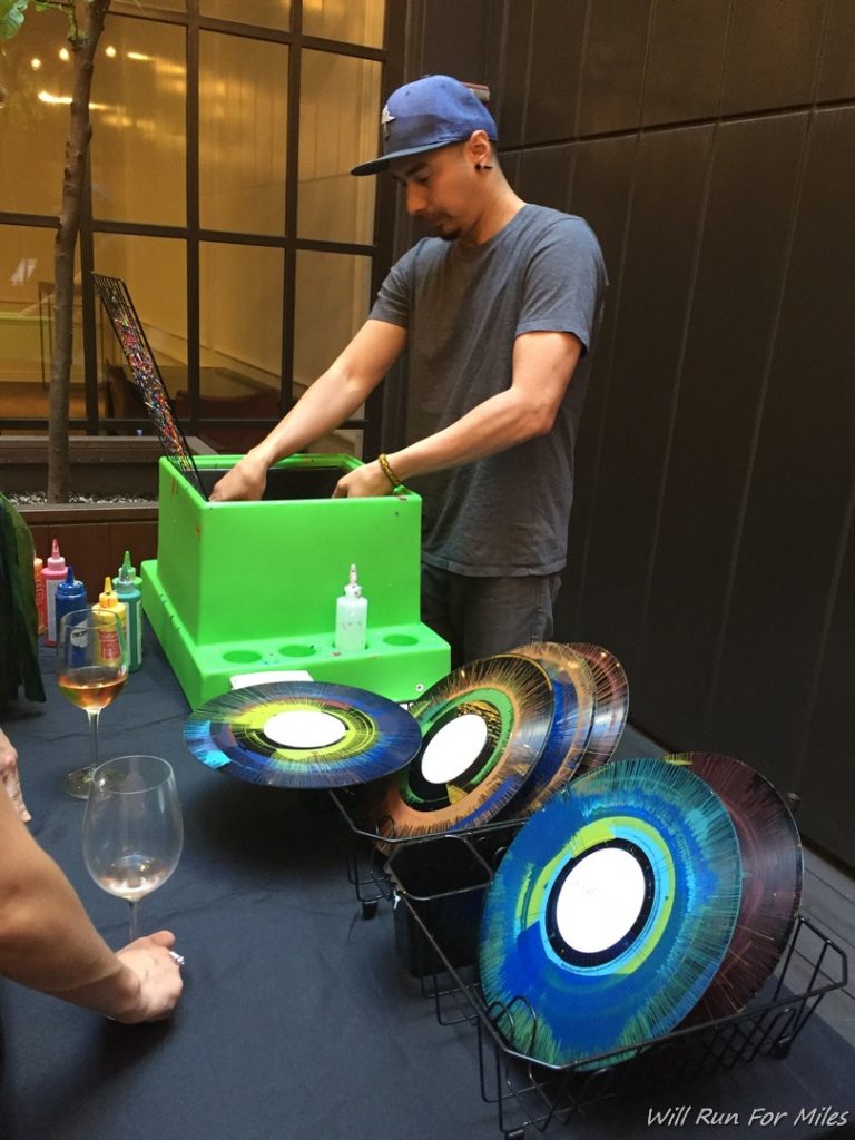 a man standing next to a table with a record player