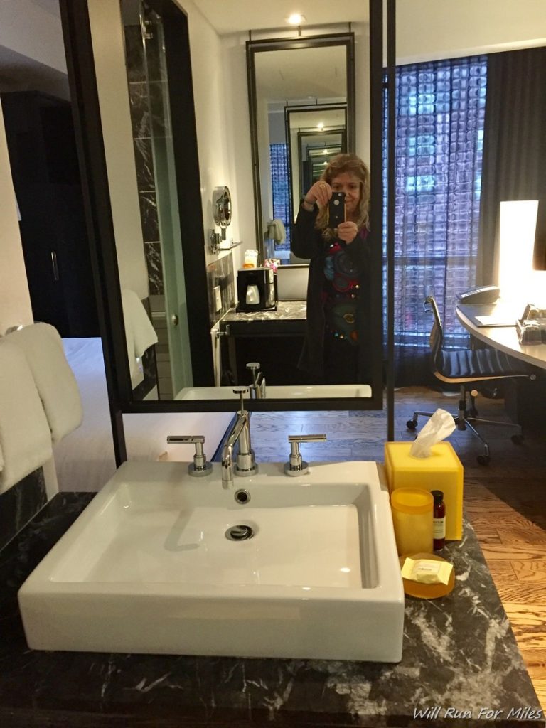 a woman taking a selfie in a bathroom mirror